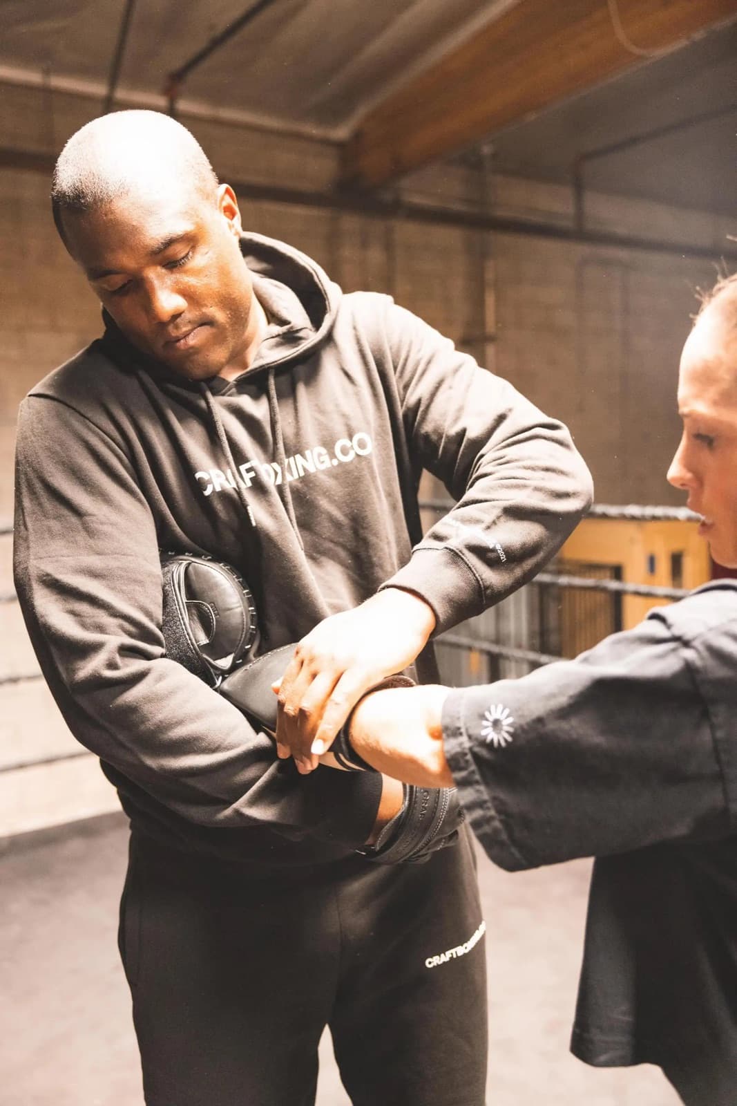 A coach wrapping a student's hands before youth boxing class